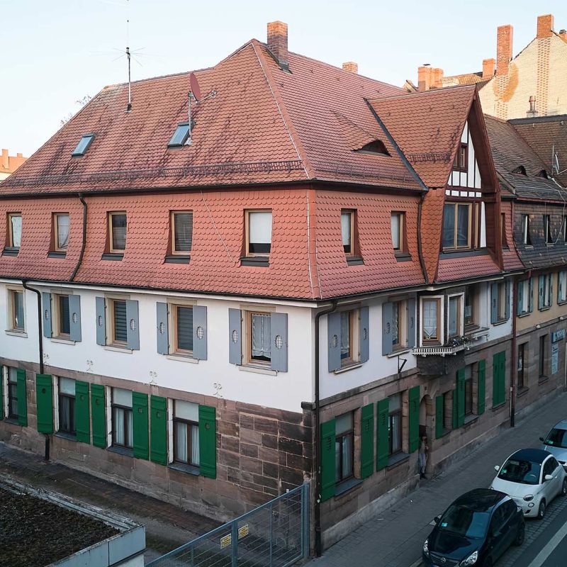 Seitliche Ansicht auf Wohngebäude mit historischer Fassade.