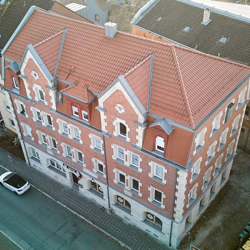 Drohnenaufsicht auf mehrstöckiges rotes Wohngebäude